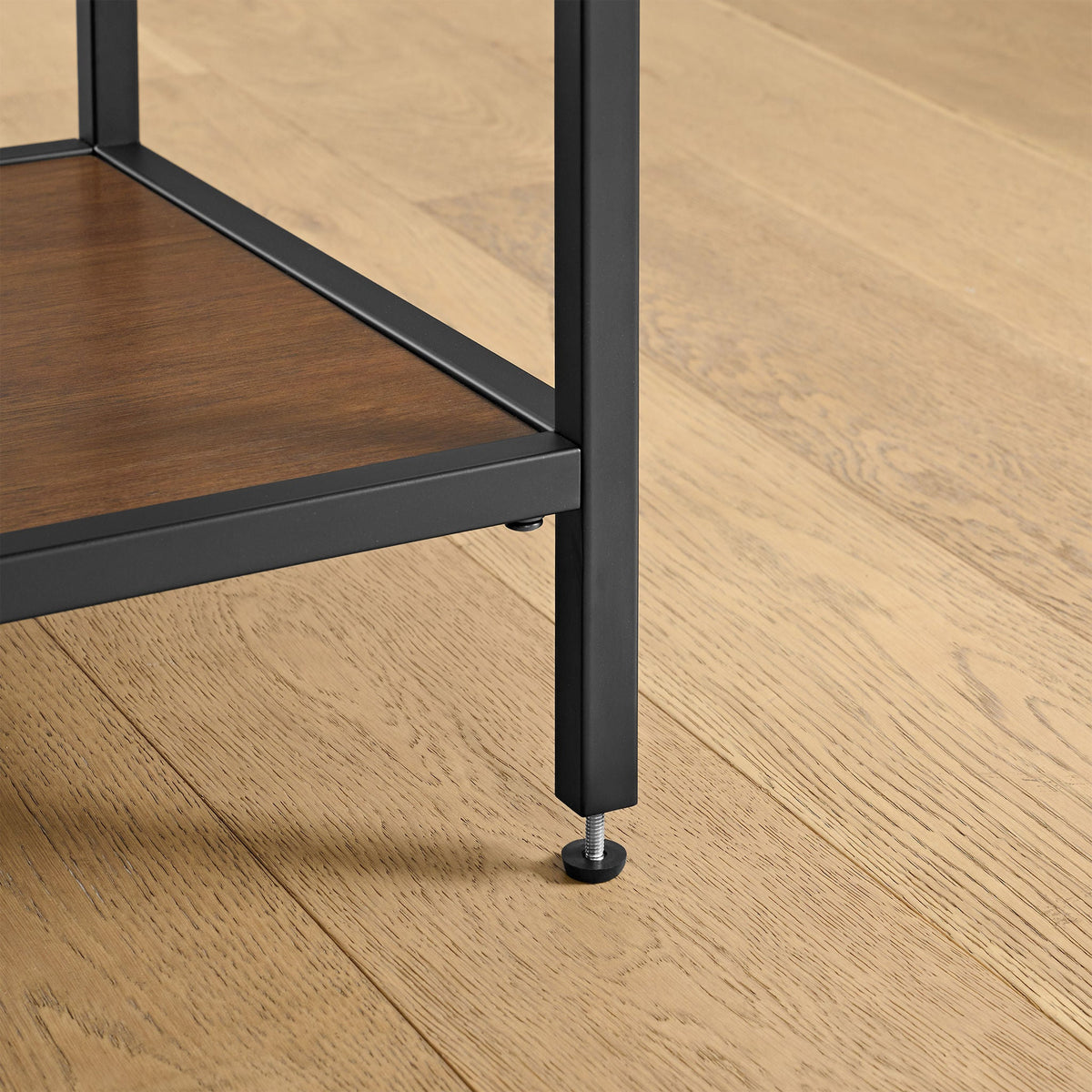 Detail of Pierson bookcase leg with adjustable leveling foot on a wood floor