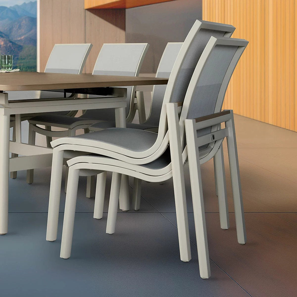 Detail view of stacked sling chairs beside the extended dining table