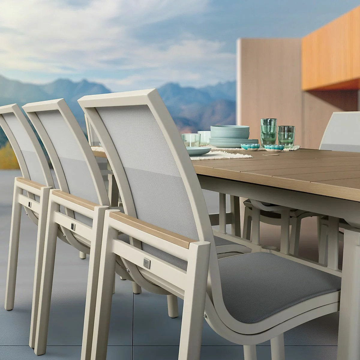 Close-up of the table set with dinnerware and glassware, with a chair in the foreground