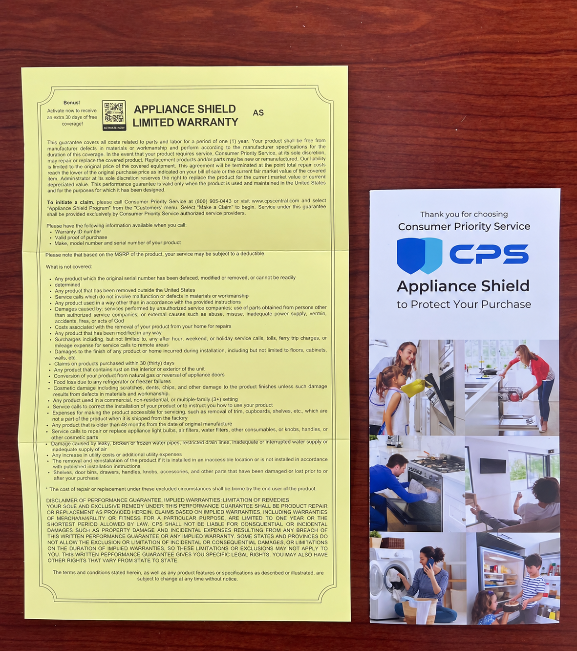 A yellow paper warranty card and a white promotional brochure for CPS Appliance Shield, displayed side-by-side on a dark wood background.