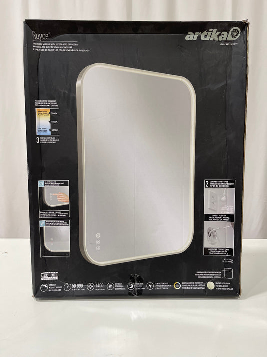 A boxed Artika Royce LED wall mirror with a black retail box showing the mirror image on the front, photographed on a white surface against a white curtain background.