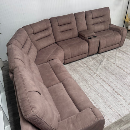 Close-up angled view of the sectional showing the storage console, cup holders, and USB charging ports
