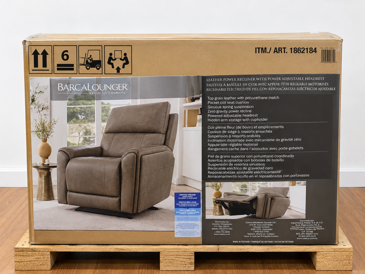 Barcalounger Hollis leather power recliner in its original Costco box (ITM 1862184) on a wooden pallet, box shows the recliner and its features