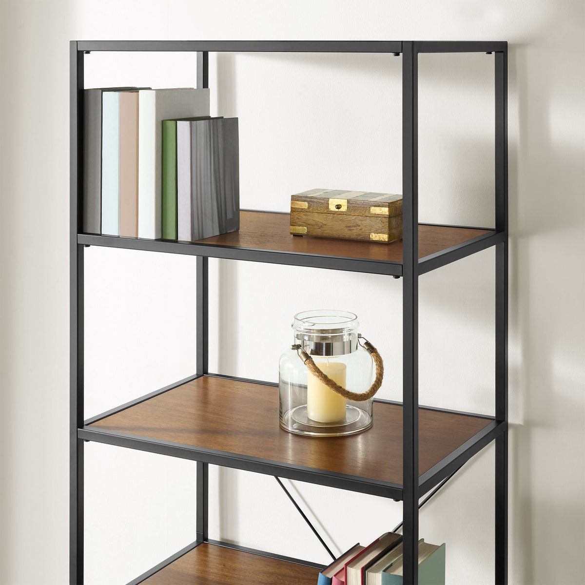 Close-up of the upper shelves of the Pierson bookcase holding books, a wooden box and a glass lantern