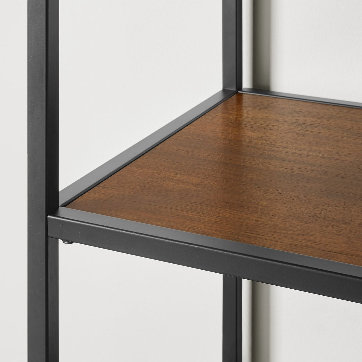 Detail of Pierson bookcase shelf corner showing brown acacia veneer set in a black powder-coated steel frame