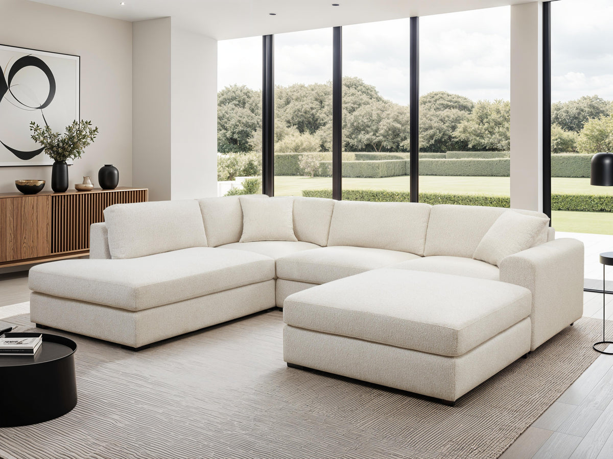 Andee sectional with ottoman styled in a modern living room with floor-to-ceiling windows and a wood sideboard
