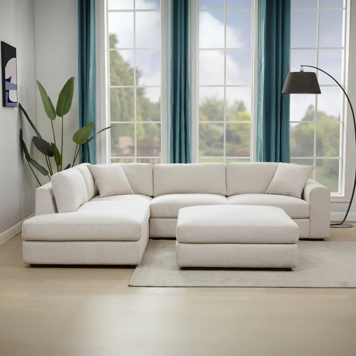 Andee sectional with ottoman in a living room with teal curtains and a tall floor lamp