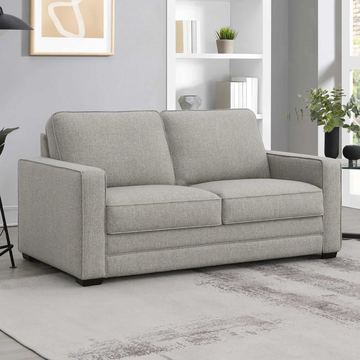 East and Vine Rosie sleeper sofa styled in a living room with white built-in shelving