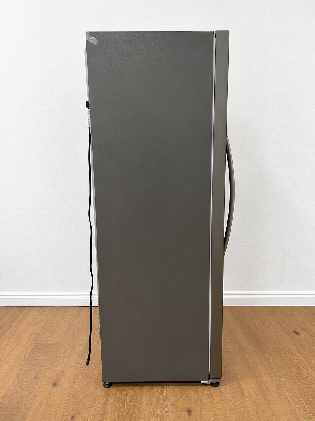 A tall, dark gray refrigerator shown from the side.