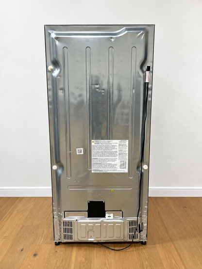 The back view of a stainless steel refrigerator or freezer, showing the metal panel, vent grilles, power cord, and product labels.