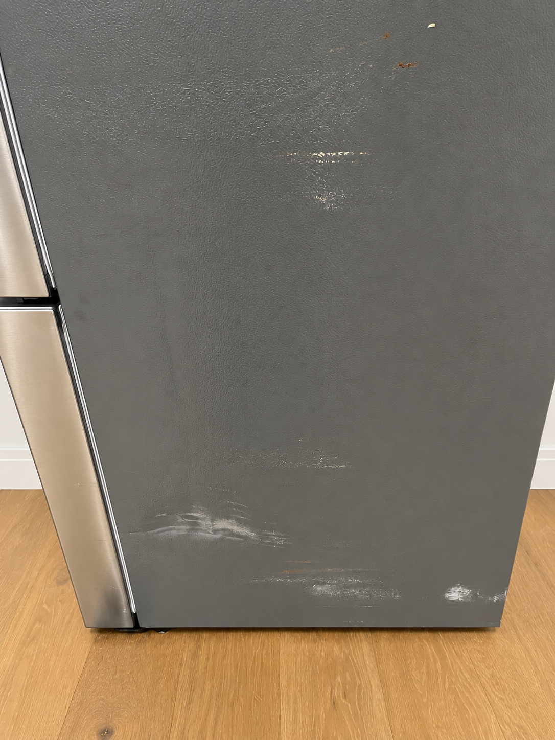 Close-up of the actual unit's lower side panel showing scuff marks and light surface blemishes