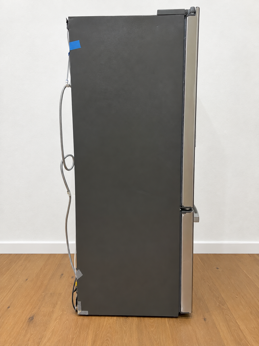 Side view of the actual unit, closed doors, with water line and cables taped along the edge