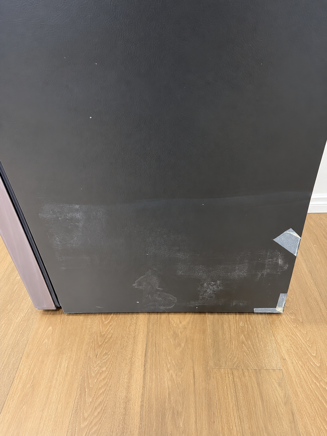 Close-up of the actual unit's lower side panel showing light scuff marks and blemishes