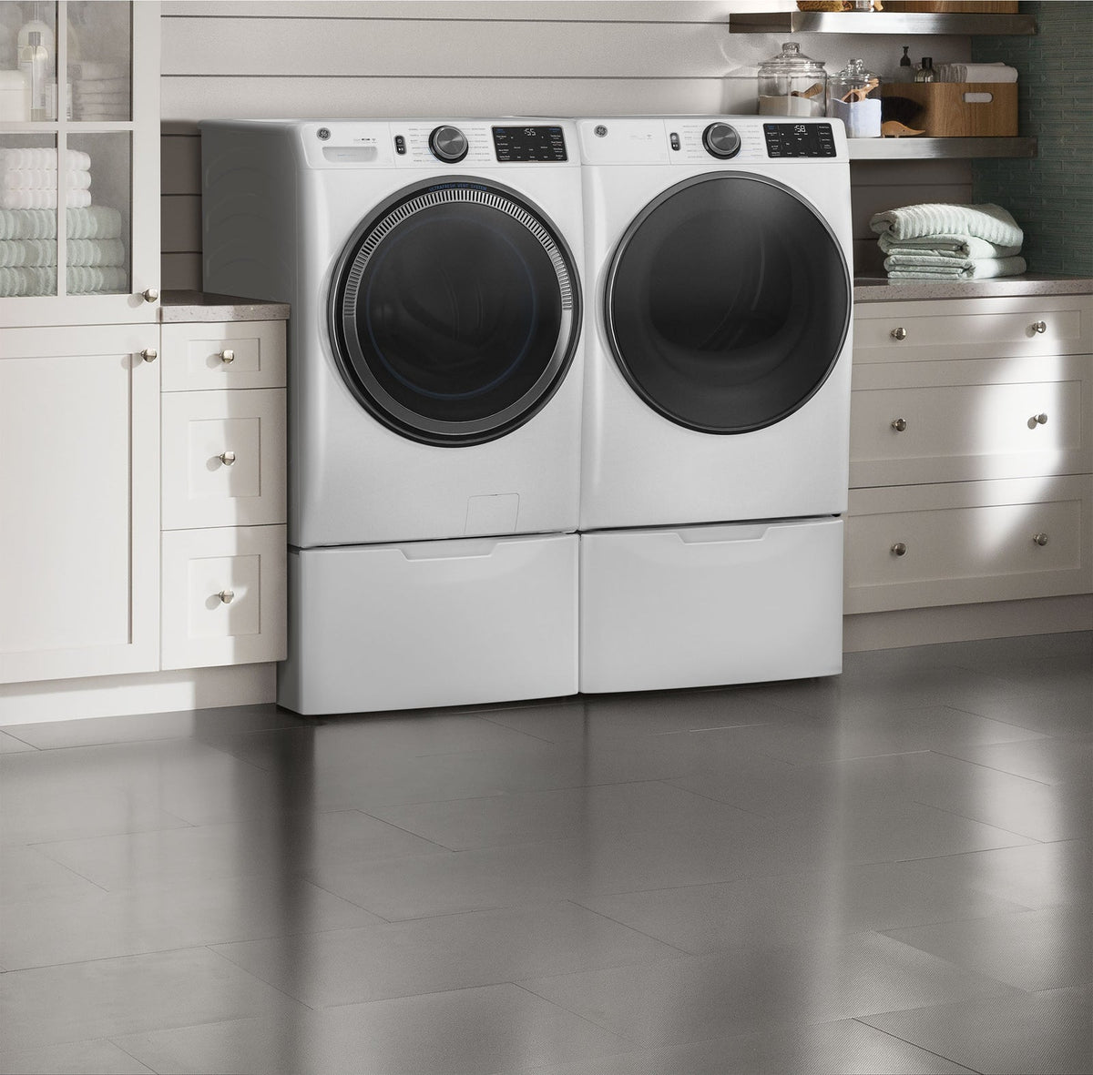 GE electric dryer in white shown paired with a matching washer in a laundry room, lifestyle shot