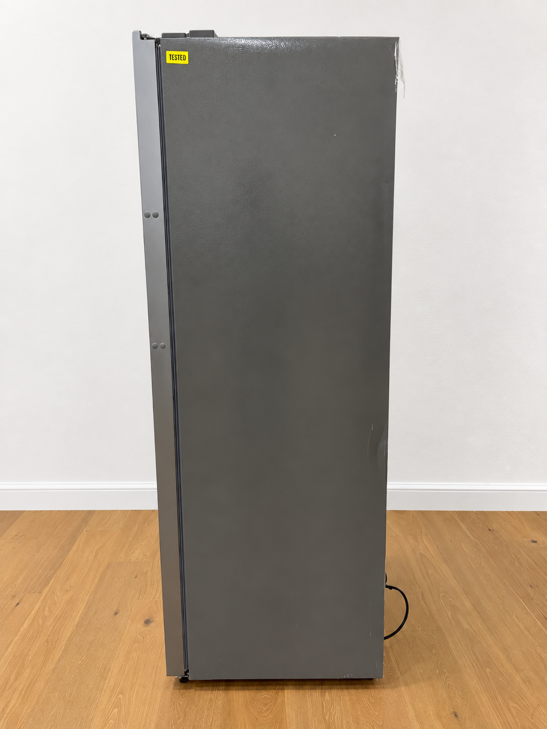 Side view of the actual unit, closed door, with a yellow Tested quality-control sticker near the top hinge