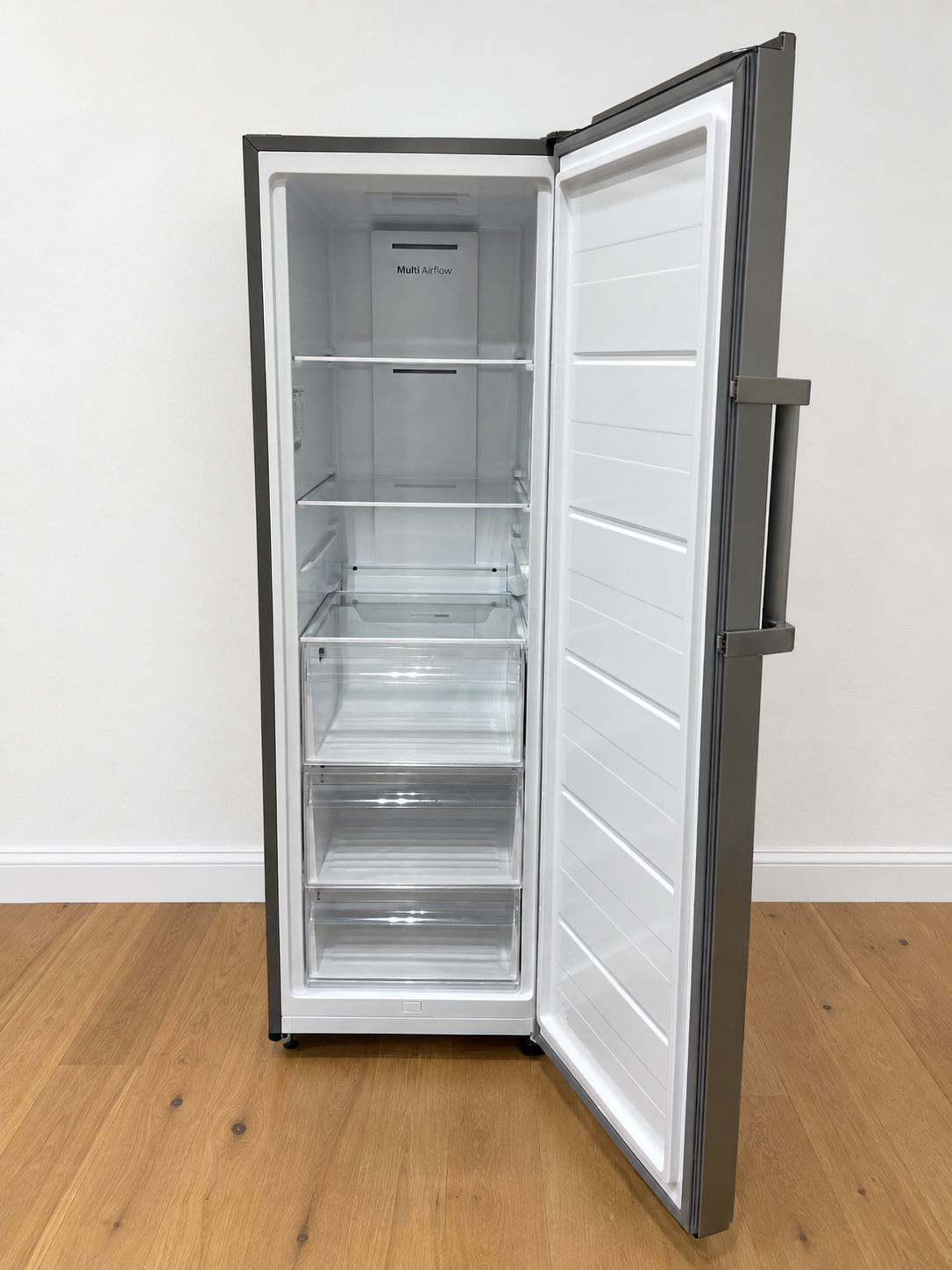 Actual unit with door open showing the empty interior, adjustable shelves, drawers, and Multi Airflow panel