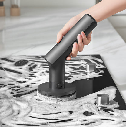 Person using the HOTO Cordless Spin Scrubber to clean a soapy kitchen countertop with the sponge pad attachment