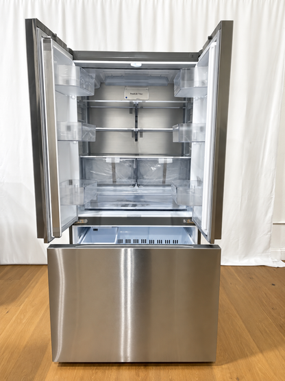A stainless steel French door refrigerator with both upper doors open, showing the interior shelves and light box.
