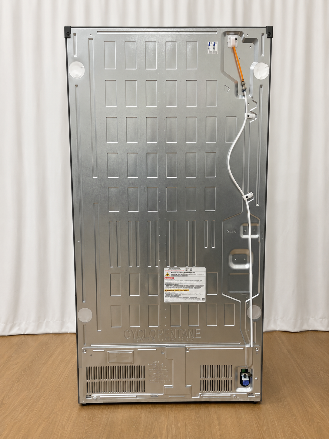 Back panel of the refrigerator showing condenser coils, wiring, and the Cyclopentane refrigerant label