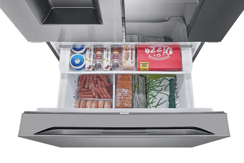 Overhead view into the open freezer drawer showing the two-tier organizer stocked with frozen pizza, macarons, sausages, bacon, and vegetables