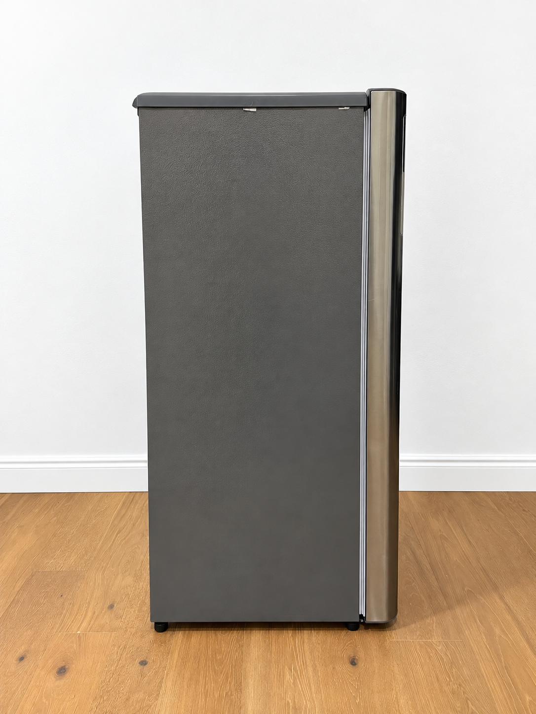 A tall, narrow refrigerator or freezer with a dark gray textured front door and a metallic silver vertical handle.
