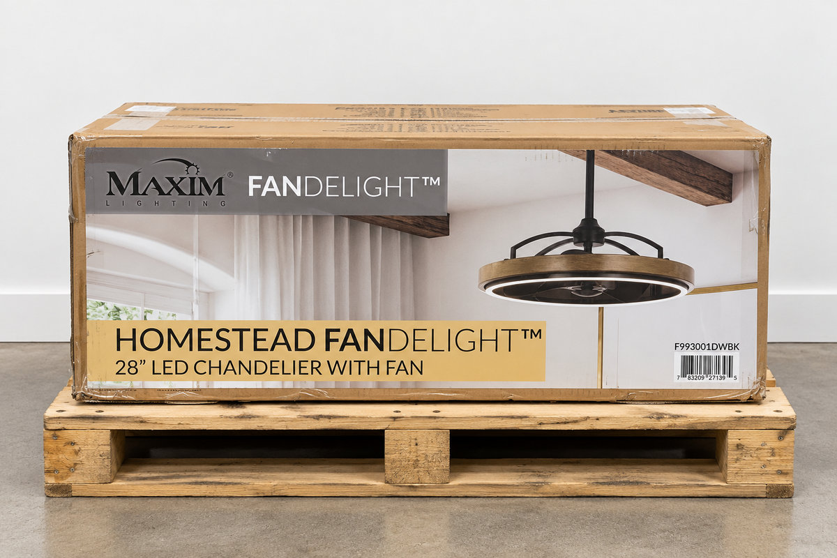 Maxim Fandelight Homestead 28-inch LED chandelier with fan, shown in its original wooden shipping box on a wooden pallet against a white wall.