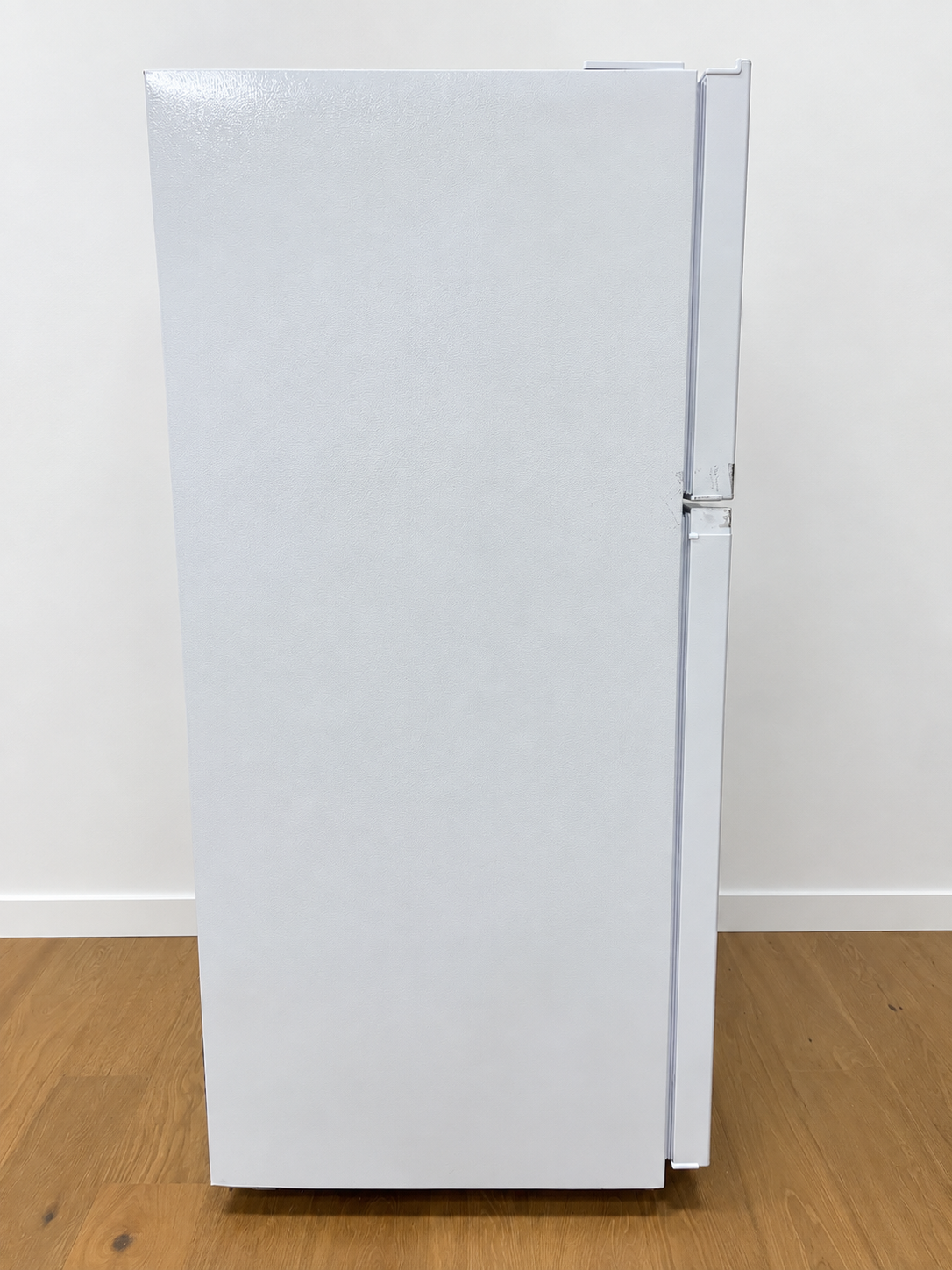 A white top-freezer refrigerator standing upright.