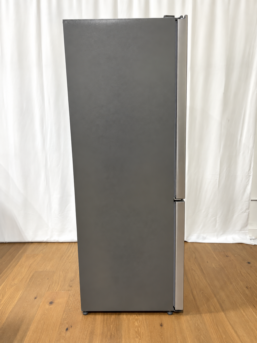 A tall, dark gray two-door refrigerator with a brushed metal finish.