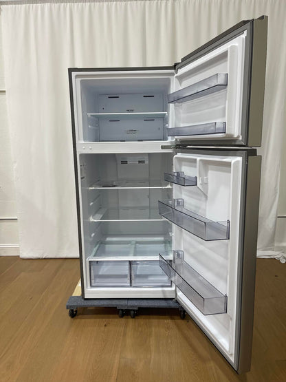 A top-freezer refrigerator with its doors open, showing a white interior with multiple shelves and translucent storage bins. The appliance has a dark gray exterior and sits on a wheeled dolly on a wooden floor in front of a white curtain backdrop.