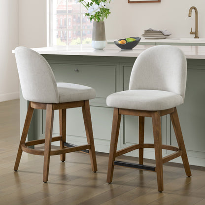 Two Pike & Main Ophelia counter height swivel stools with off-white fabric seats and walnut-tone wood frames at a kitchen island