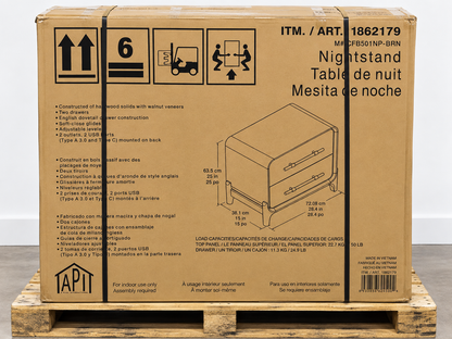 A large brown cardboard shipping box for a TAPI Nightstand, placed on a wooden pallet. The box shows product details, dimensions, and a small photo of the nightstand on the front.