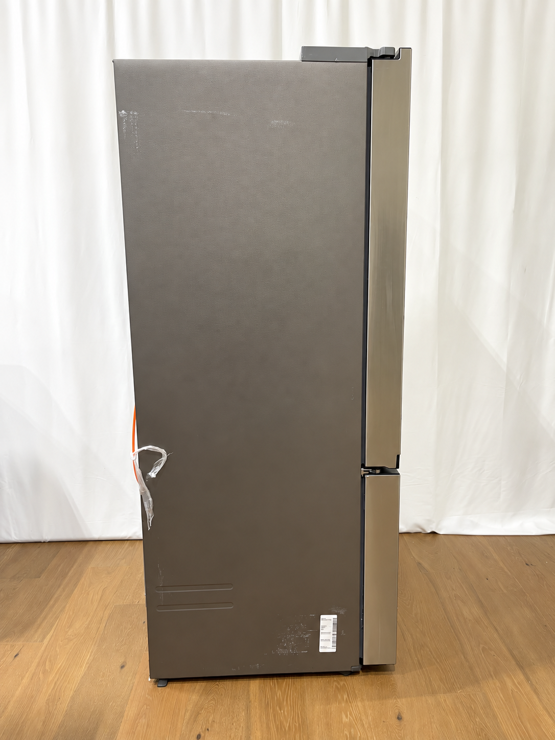 A tall, dark gray double-door refrigerator with a brushed metal finish.