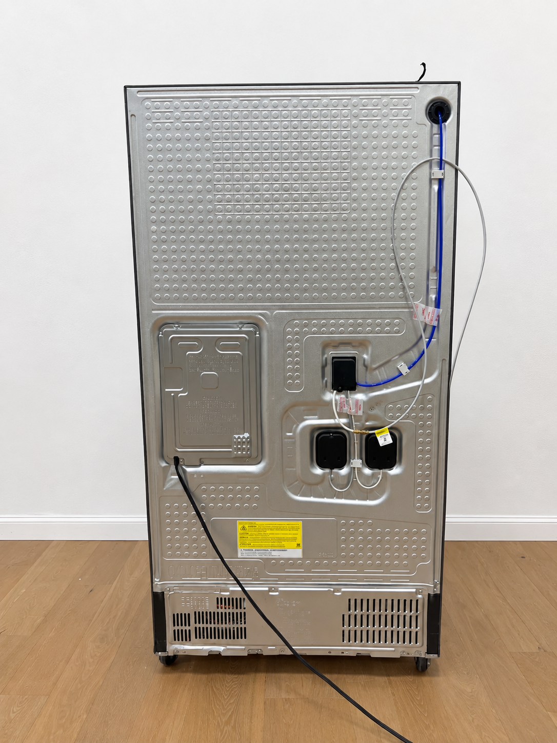 Back panel of the actual unit showing water line and rear connections