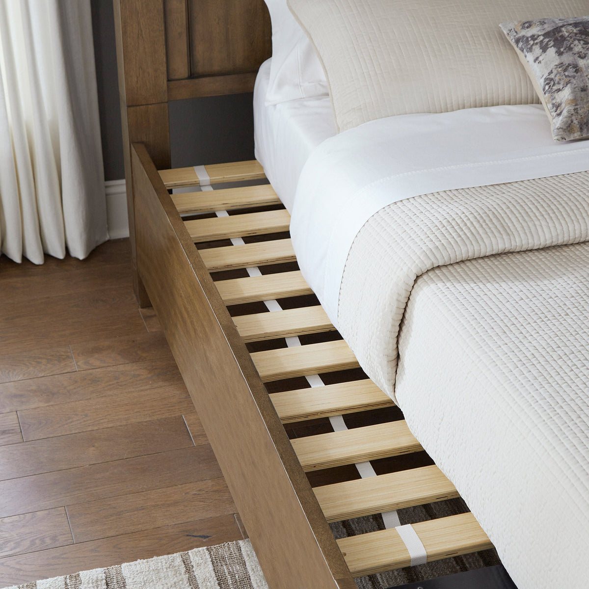 Pierson storage bed with mattress pulled back showing the included wooden slat roll and side rail