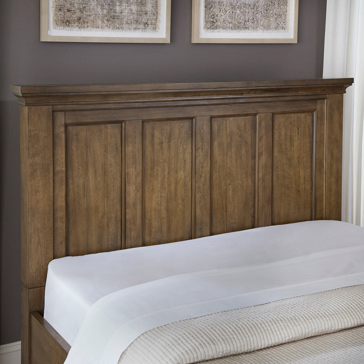 Close-up of the Pierson storage bed panel headboard with crown molding in dark caramel finish