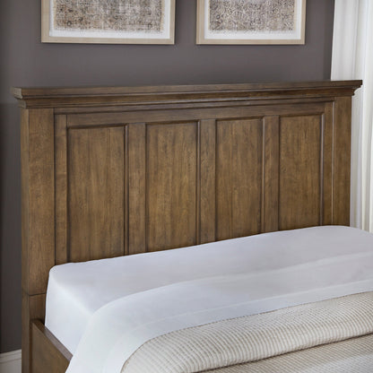 Close-up of the Pierson storage bed panel headboard with crown molding in dark caramel finish
