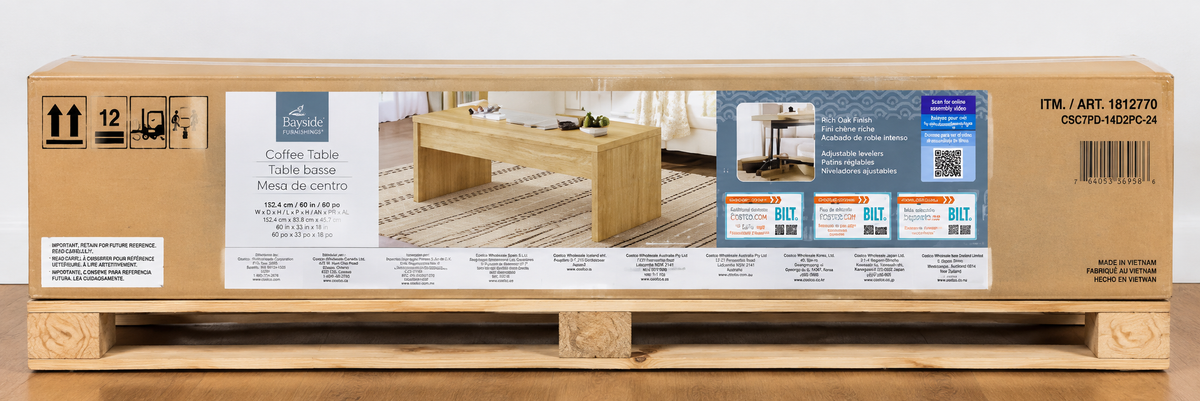 A packaged CBF20 coffee table made of light natural wood, sealed in a large cardboard shipping box with printed product details and a photo of the assembled table.